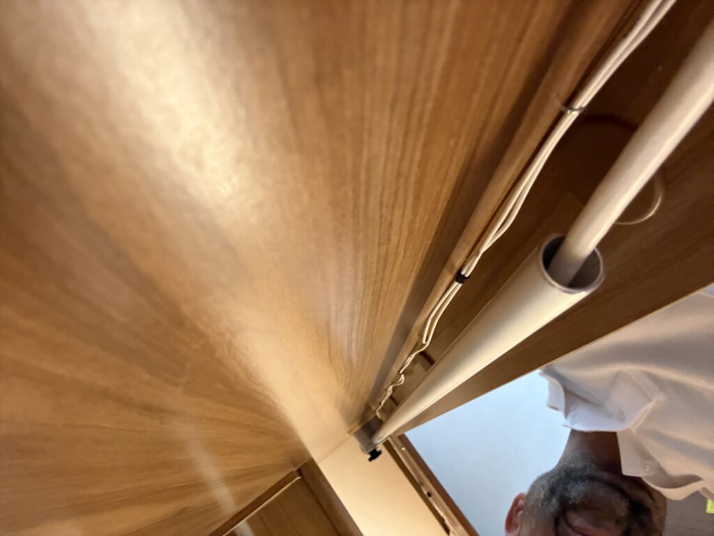 Gammal antenngenomföring och stång i taket på husvagn sedd inifrån garderoben